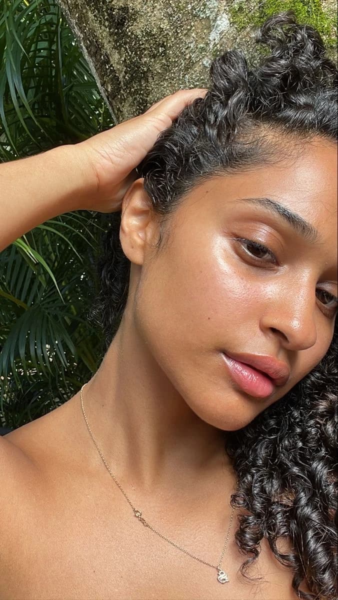 Femme aux cheveux bouclés, peau éclatante, lumière naturelle