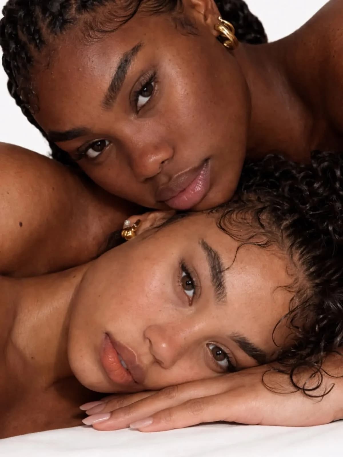 Deux femmes, têtes rapprochées, peaux lumineuses