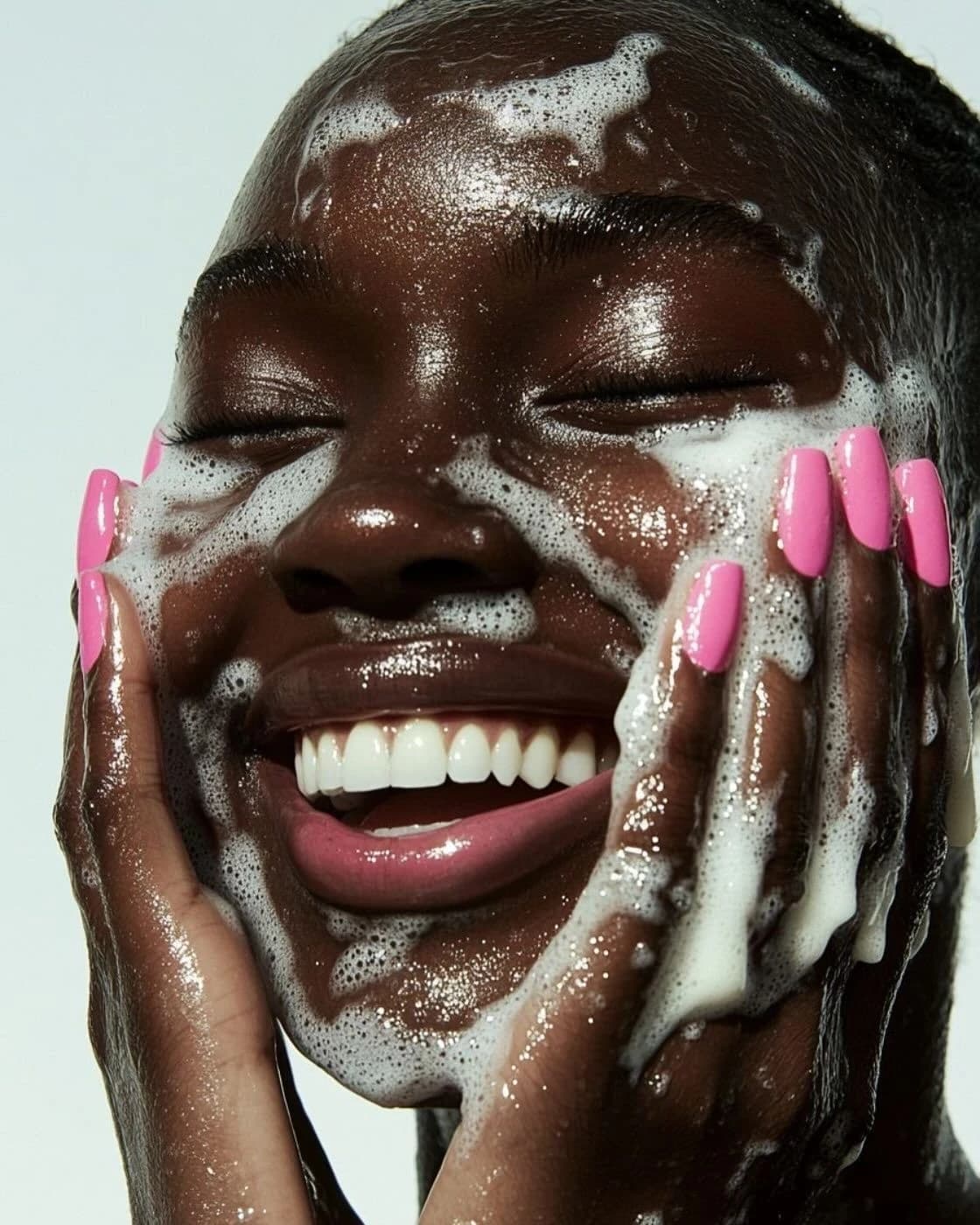 Femme riant, le visage couvert de mousse nettoyante